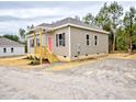 Inviting single-story house with a covered front porch, complemented by neat landscaping and exterior lighting at 48 S Grace Way, Henderson, NC 27537