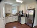 Modern kitchen boasts stainless steel appliances, white cabinetry, and hardwood floors at 509 Coleman St, Raleigh, NC 27610