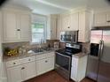 Bright kitchen with stainless steel appliances, white cabinetry, and granite countertops at 509 Coleman St, Raleigh, NC 27610