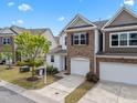 Inviting townhome with stone and siding, showcasing an attached garage, well-kept lawn, and 'Coming Soon' sign at 5518 Jessip St, Morrisville, NC 27560