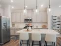 Modern kitchen with stainless steel appliances, large island, and stylish pendant lighting at 6010 Grey Colt Way, Durham, NC 27703