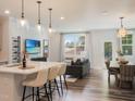 Bright open-concept living space with modern finishes, including a kitchen island, and a view to the backyard at 6010 Grey Colt Way, Durham, NC 27703