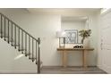 Bright entryway with staircase, wooden console table, mirror, and modern decor at 613 Cassa Clubhouse Way, Knightdale, NC 27545