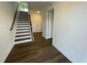 Inviting foyer with stylish hardwood flooring, a staircase with white risers, and neutral walls at 621 Cassa Clubhouse Way, Knightdale, NC 27545