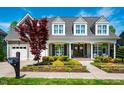 Inviting two-story home with a covered front porch and attached garage, surrounded by manicured gardens at 658 Bennett Mountain Trce, Chapel Hill, NC 27516