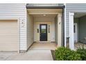 Inviting front entrance with a beige garage door, neutral siding and classic black front door at 72 S Grey Abbey Dr, Clayton, NC 27527