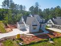 Beautiful new construction home with gray exterior, attached garage, and a lush, wooded backyard at 7301 Wexford Woods Ln, Wake Forest, NC 27587