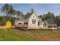 New construction two-story home with light gray brick, white trim, and black roof at 7301 Wexford Woods Ln, Wake Forest, NC 27587