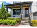 Inviting front porch with stone pillars, manicured landscaping, and a stylish front door at the home's entry at 7510 Latteri Ct, Raleigh, NC 27613