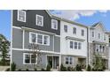 Stylish townhome displaying gray siding, large windows, and lush landscaping at 768 Dorset Stream Dr, Fuquay Varina, NC 27526