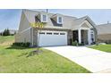 A cozy single-Gathering home boasts a two-car garage, stone accents, and a beautiful lawn at 769 Ashley Woods Dr, Gibsonville, NC 27249