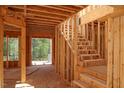 Interior view displays the wood frame and staircase construction, highlighting natural light and design at 7961 Wexford Waters Ln, Wake Forest, NC 27587