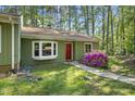 Charming home featuring a well maintained front yard, bay window, and a vibrant red front door at 8 Bluebell Ct, Durham, NC 27713