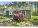 Charming home featuring a well maintained front yard, bay window, and a vibrant red front door at 8 Bluebell Ct, Durham, NC 27713