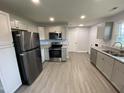 Spacious kitchen featuring modern stainless steel appliances, granite countertops and grey wood flooring at 83 Brentwood Dr, Selma, NC 27576