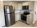Well-lit kitchen featuring stainless steel appliances, granite countertops and sleek white cabinets at 83 Brentwood Dr, Selma, NC 27576