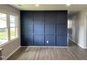Spacious living room boasts wood plank flooring and a stylish dark blue accent wall at 83 Brentwood Dr, Selma, NC 27576