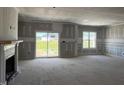 Spacious living room features a fireplace, large windows, and sliding glass door to backyard at 871 Olive Branch Dr, Smithfield, NC 27577