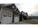 Well-maintained home featuring an attached two car garage, stone accents, and manicured landscaping at 901 Hollymont Dr, Holly Springs, NC 27540