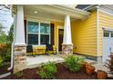 Inviting front porch with stone-clad columns and comfortable seating perfect for relaxing at 91 Cliffdale Rd, Chapel Hill, NC 27516