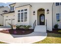 Close up of a home's entrance, showcasing the front door, landscaping, and architectural details, including a window at 928 Lily Claire Ln, Fuquay Varina, NC 27526