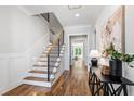 Welcoming home foyer with hardwood flooring, a staircase, decorative console table, and plenty of natural light at 928 Lily Claire Ln, Fuquay Varina, NC 27526