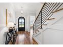 Inviting home foyer featuring hardwood floors, elegant staircase, decorative console table, and a stylish pendant light at 928 Lily Claire Ln, Fuquay Varina, NC 27526