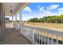 View of the property from the expansive front porch with decorative lighting fixture at 9391 Turkey Way, Middlesex, NC 27557