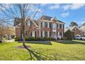Beautiful two-story brick home with a green lawn, professional landscaping, and blue sky at 101 Silk Leaf, Cary, NC 27518