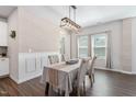 Dining room with an elegant light fixture, wainscoting, and large windows at 1036 S Fieldhaven Dr, Fuquay Varina, NC 27526