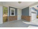 Covered front porch with neutral colors and stone accents providing an inviting curb appeal at 1120 Copper Beech Ln, Wake Forest, NC 27587