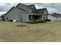 Gray home with dark shutters, covered front porch and landscaping at 116 Polenta Fields Dr, Smithfield, NC 27577