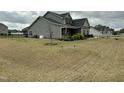 A spacious yard surrounds the gray home, offering ample space for outdoor activities at 116 Polenta Fields Dr, Smithfield, NC 27577