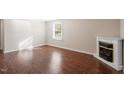 Inviting living room with hardwood floors, a corner fireplace, and ample natural light at 116 W Mciver St, Zebulon, NC 27597