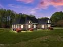 Beautiful brick home with lush green lawn, mature trees, and landscape at 1174 Robertson Rd, Roxboro, NC 27574