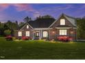 Beautiful brick home at dusk featuring manicured landscaping and inviting entrance with manicured front lawn at 1174 Robertson Rd, Roxboro, NC 27574