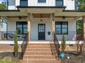 Charming front porch with brick stairs, black railings, ceiling fans, and craftsman columns at 1312 Lancaster St, Durham, NC 27701