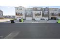 Rear exterior view of townhomes featuring garages and private balconies at 1335 Herb Garden Way, Apex, NC 27502