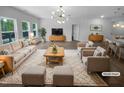 Bright living room featuring stylish furniture, neutral tones, and modern chandelier at 136 W Tecoma Ln, Clayton, NC 27520