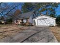 Brick home with a long driveway leading to a detached garage at 1408 Edgebrook Dr, Garner, NC 27529