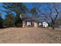 Brick house with a detached garage set on a grassy lawn at 1408 Edgebrook Dr, Garner, NC 27529