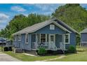 Blue house featuring a front porch and well-maintained landscaping in a serene setting at 1542 Albright Ave, Burlington, NC 27215