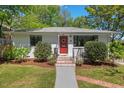 A charming single-story home with a well-manicured lawn and inviting red front door at 1804 N Alston Ave, Durham, NC 27701