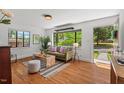 Sunlit living room featuring gleaming hardwood floors, modern decor, and large windows offering views of the lush greenery at 1804 N Alston Ave, Durham, NC 27701