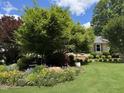Lush green lawn with ornamental trees and flower bed near the front of the home at 2009 Mallard Ln, Raleigh, NC 27609