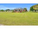 Spacious brick home on a large lot with a green lawn and mature trees, featuring dormer windows at 201 Wendy Pl, Benson, NC 27504