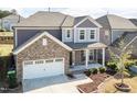 Charming two-story home with stone accents, a two-car garage, and a beautifully landscaped front yard at 2221 Holtwood Way, Apex, NC 27523