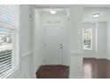 Bright foyer featuring hardwood floors, white trim, transom window above the front door, and natural light at 2227 Rocky Bay Ct, Cary, NC 27519