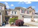 Charming townhome boasts tidy landscaping, an attached two-car garage, and a patriotic display at 225 Mayfield Dr, Apex, NC 27539