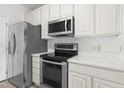 Modern kitchen featuring stainless steel appliances, white cabinets, and quartz countertops at 2421 Kudrow Ln, Morrisville, NC 27560